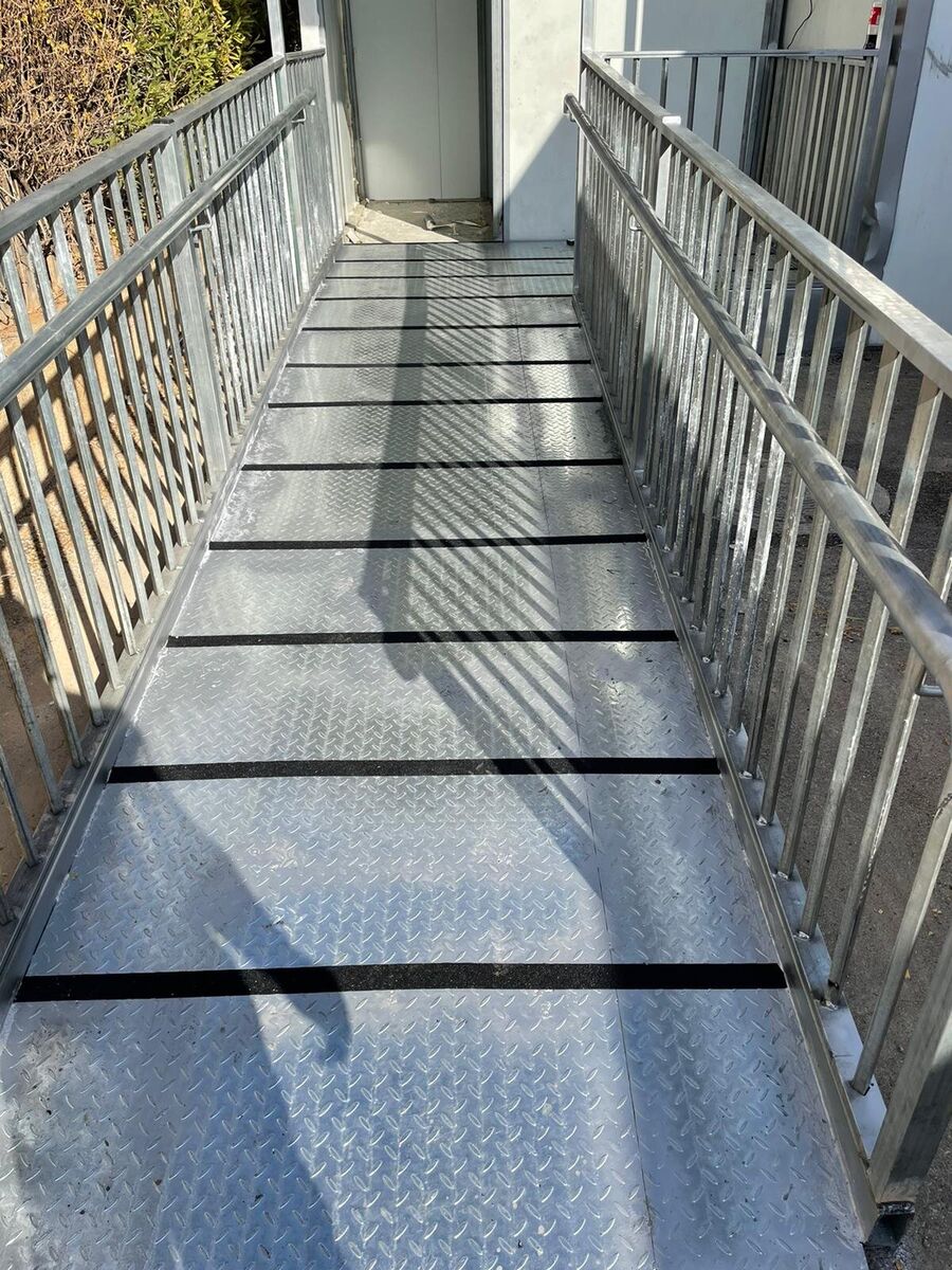 מבט לאורך משטח מתכת נגד החלקה עם מעקות משני הצדדים